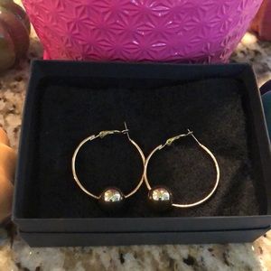 Gold tone hoop earrings with gold tone ball.